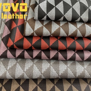 May include: A selection of fabric samples featuring a geometric triangle design. The fabrics showcase a range of colours, including black, brown, red, pink, and grey. The text "VOVO leather" is visible in the upper left corner.