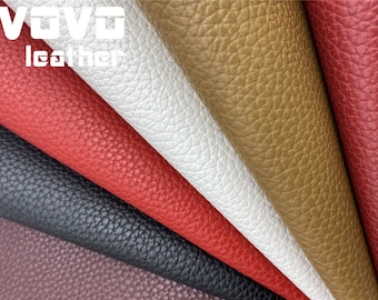 May include: Close-up of five different colors of faux leather fabric. The colors are burgundy, black, red, white, and brown. The fabric has a textured surface.