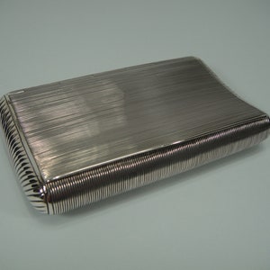 An antique silver tobacco box, shallow curved model.