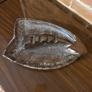 Peut inclure: Un cendrier en céramique brun en forme de poisson avec un glaçage blanc. Le cendrier a quatre indentations pour les cigarettes.