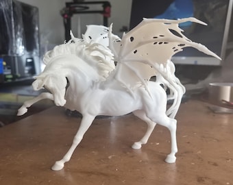 May include: A white sculpture of a winged horse, also known as a pegasus, with detailed wings and flowing mane. The sculpture is posed mid-stride, with one leg raised. The sculpture is approximately 12 inches long.