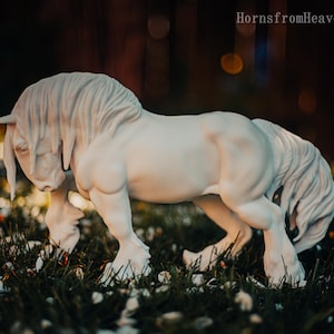 May include: A white horse sculpture with a flowing mane and tail, standing in a grassy area with small white petals. The sculpture has a detailed, realistic appearance. The text "HornsfromHeaven 2026" is visible in the upper right corner.