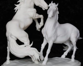 May include: White porcelain sculpture of two horses in a dynamic pose. The horses are facing each other, with one rearing up on its hind legs and the other standing on all fours. The sculpture is set on a white oval base.