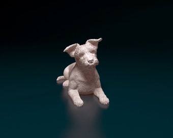 May include: A white ceramic figurine of a small dog sitting on a dark blue surface. The dog has a fluffy coat and is looking to the side.