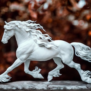 Pode incluir: Escultura branca de um cavalo a correr com crina e cauda esvoaçantes. O cavalo é retratado numa pose dinâmica, com as pernas estendidas como se estivesse a galope. A escultura está sobre um fundo desfocado de cores outonais.