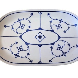 Könnte beinhalten: Weiße ovale Servierplatte mit einem blauen und weißen Blumenmuster. Das Muster zeigt zarte Schwünge und stilisierte Blumen.