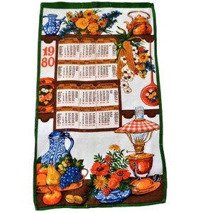 Op de afbeelding: Een vintage keukendoek met een groene rand en een witte achtergrond. De handdoek heeft een kalender voor het jaar 1980, een stilleven met fruit, bloemen en keukengerei, en de tekst "1980".