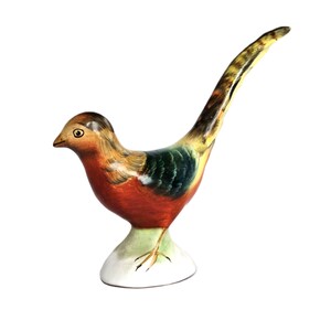 May include: A decorative bird figurine featuring a painted finish with a brown head, a vibrant orange-red chest, and dark green wings. The bird has a long, slender, patterned tail and stands on a white, rounded base with visible feet.