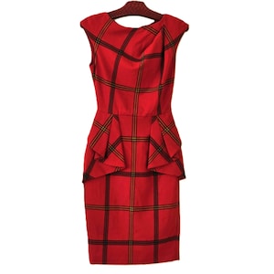 以下が含まれることがあります： 黒と黄色のチェック柄のノースリーブの赤いドレス。 ドレスはドレープネックラインとウエストにペプラムのディテールが特徴です。 ドレスは木製のハンガーにかかっています。