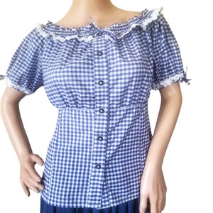 May include: A blue and white gingham button-up blouse with a white lace trim around the neckline and sleeves. The blouse has a fitted waist and short sleeves.