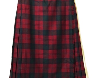 May include: A red and black tartan skirt with a pleated design. The skirt is made of a woven fabric and features a classic plaid pattern. The skirt is hanging on a wooden hanger with a metal clasp.