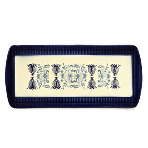 Puede incluir: Una bandeja rectangular de servir azul y blanca con un patrón floral decorativo. La bandeja tiene un borde elevado y una superficie lisa.
