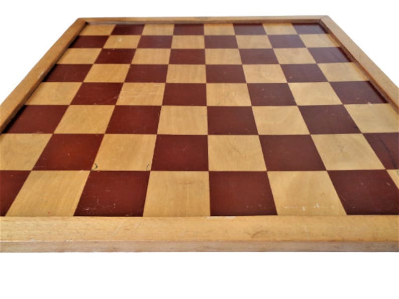 May include: A wooden chessboard with a brown and natural wood checkered pattern. The board has a simple wooden frame.