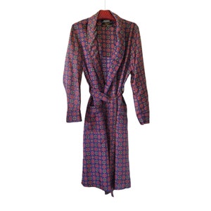 May include: A long, blue silk robe with a red and yellow geometric pattern. The robe has a shawl collar and a tie belt.