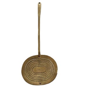 Pode incluir: Um utensílio de cozinha de latão com uma alça longa e uma cabeça redonda perfurada. A cabeça tem um padrão de pequenos furos.