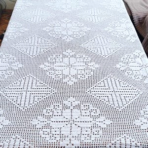 Peut inclure: Nappe en crochet blanc avec un motif floral délicat. La nappe est faite de fil fin et a un aspect délicat et ajouré.