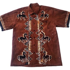 Peut inclure: Une chemise boutonnée à manches courtes de couleur marron avec un motif batik de chevaux et de motifs géométriques.