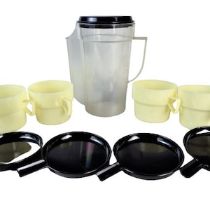 Könnte beinhalten: Ein Vintage-Set aus Plastik-Küchenutensilien in Gelb und Schwarz. Das Set enthält eine Kanne, vier Tassen und vier kleine Pfannen.