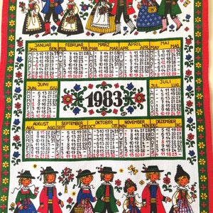 Può includere: Un asciugamano da cucina vintage con un calendario colorato per l'anno 1983. Il calendario presenta costumi tradizionali popolari e motivi floreali. Ogni mese è etichettato in tedesco e inglese.