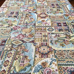 Könnte beinhalten: Ein Wandteppichstoff mit Patchwork-Muster, das verschiedene geometrische Muster und florale Motive in Blautönen, Grün, Braun, Rot und Gelb zeigt.