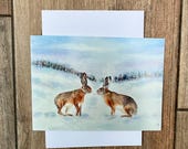 Hares in snow greeting card
