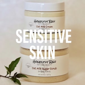 May include: Two jars of skin care products, both labeled "Honestly Raw Natural Beauty". The top jar is labeled "Oat Milk Cream for face + body" and the bottom jar is labeled "Oat Milk Sugar Scrub for face + body, net wt 8 oz/227g". Both jars are white with a creamy white product inside. The text "SENSITIVE SKIN" is superimposed over the jars.