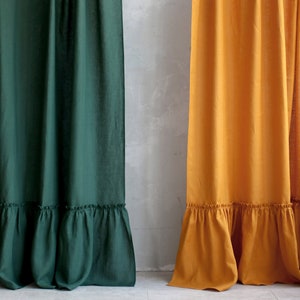 Puede incluir: Dos cortinas de lino con un dobladillo con volantes. La cortina de la izquierda es de color verde oscuro y la cortina de la derecha es de color amarillo mostaza.
