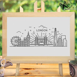 May include: Black and white line art illustration of the London skyline, including Big Ben, the London Eye, Tower Bridge, and the Shard. The text "LONDON" is above the skyline.