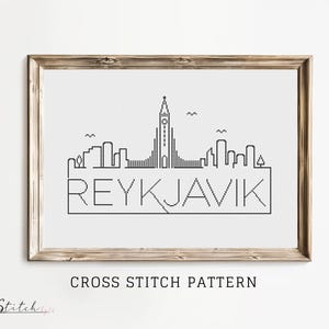 K&ouml;nnte beinhalten: Schwarzwei&szlig;es Kreuzstichmuster der Skyline von Reykjavik mit dem Stadtnamen in einem Banner darunter.