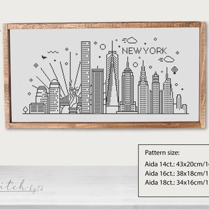 May include: Black and white cross-stitch pattern of the New York City skyline. The pattern includes the Empire State Building, the Chrysler Building, and the Statue of Liberty. The pattern is framed in a wooden frame. The pattern size is listed for Aida 14ct, 16ct, and 18ct.
