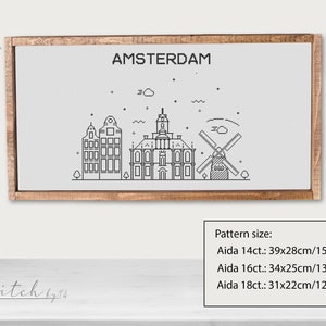 May include: A black and white line drawing of the Amsterdam skyline, including a windmill, buildings, and a cloud. The text "AMSTERDAM" is at the top of the image. The pattern size is listed below the image: Aida 14ct.: 39x28cm/15.4x11inch, Aida 16ct.: 34x25cm/13.4x9.8inch, Aida 18ct.: 31x22cm/12.2x8.7inch.