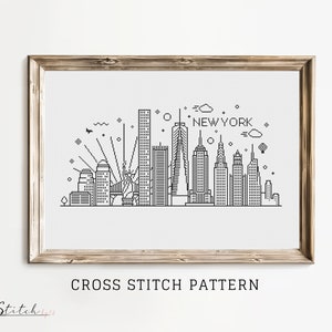 May include: Black and white cross stitch pattern of the New York City skyline, including the Empire State Building, the Chrysler Building, and the Statue of Liberty. The pattern includes the text "NEW YORK" above the skyline.