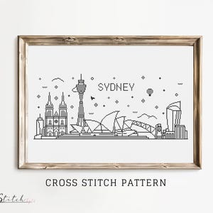 Op de afbeelding: Zwart-witte lijntekening van een kruissteekpatroon van de skyline van Sydney, inclusief het Sydney Opera House, de Sydney Harbour Bridge en de Sydney Tower. De tekst "SYDNEY" staat boven de skyline. De tekst "CROSS STITCH PATTERN" staat onder de skyline.