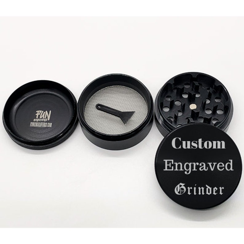 Puede incluir: Triturador de metal negro con un mensaje grabado personalizado que dice "Custom Engraved Grinder". El triturador tiene una tapa de metal negro con el texto "FUN engravings FUNengravings.com" impreso en ella.