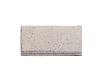 May include: A light beige cork wallet with a subtle speckled pattern. The wallet is closed and has a simple, minimalist design.