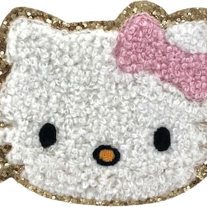 May include: A white fluffy Hello Kitty character with a pink bow and gold glitter trim.