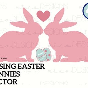 Op de afbeelding: Twee roze konijnen die elkaar kussen met een rood hart erboven. Ze zitten naast twee blauwe en witte paaseieren. De tekst "KISSING EASTER BUNNIES VECTOR" staat onder de konijnen.