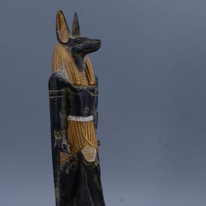 Escultura de Anubis, dios egipcio del más allá, en piedra negra y dorada. Figura pintada a mano para decoración de altar, regalos y energía espiritual.