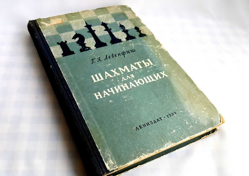 May include: A vintage green book titled "Шахматы для начинающих" (Chess for Beginners) by Т.Я. Лебедевич. The book cover features a black and white chessboard with chess pieces in silhouette.