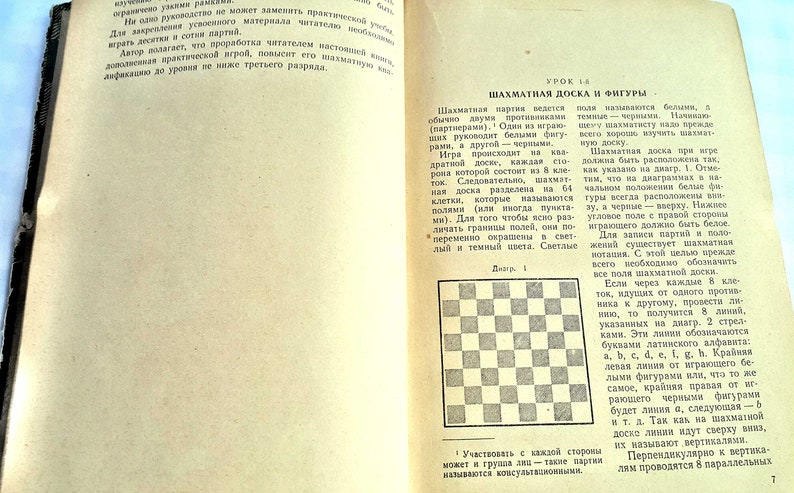 May include: A black and white checkered chessboard with a diagram showing the starting position of the pieces. The text "Diagram 1" is printed below the chessboard. The text "Chessboard and Pieces" is printed in a larger font above the diagram.