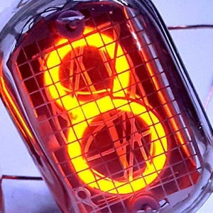 Może przedstawiać: Czerwona lampa Nixie wyświetlająca cyfrę 8. Lampa jest zapalona, a cyfra jest widoczna przez kratkę.