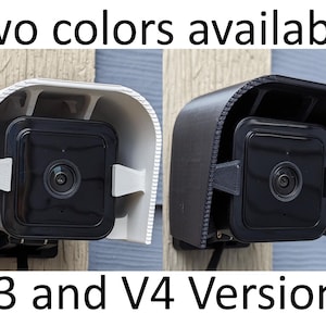 May include: Two security camera covers in white and black, designed to protect Ring security cameras from the elements. The covers are labeled "V3 and V4 Versions".