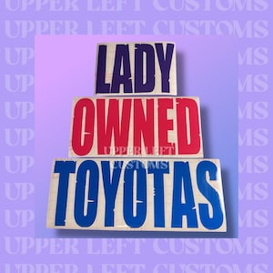 May include: Three wooden signs stacked vertically. The top sign reads "LADY" in dark blue, the middle sign reads "OWNED" in red, and the bottom sign reads "TOYOTAS" in blue. The background is a gradient of purple and light purple.