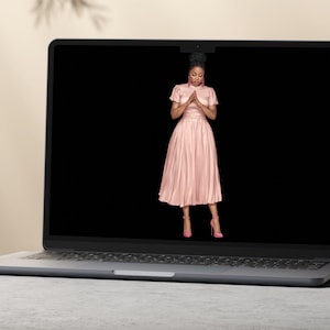 K&ouml;nnte beinhalten: Ein silberner Laptop, der ein digitales Bild einer Person in einem hellrosa, kurz&auml;rmeligen, plissierten Midikleid mit passenden rosa High-Heels zeigt, die auf dem Bildschirm vor einem einfarbigen schwarzen Hintergrund steht.
