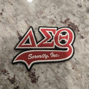 Small Delta Symbols with tail; iron-on embroidered 3.5&quot; patch; red, white with black trim