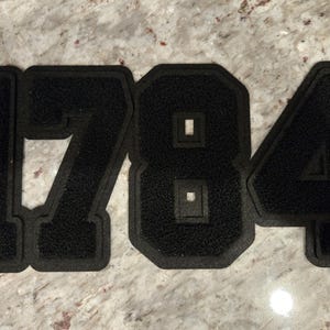 May include: Black felt numbers 1784, each number is individually cut out and has a white outline.