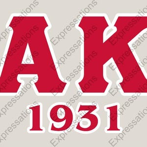 May include: Red "AK 1931" graphic on a light beige background. The letters "AK" are large and bold, with a white outline. The numbers "1931" are below the letters, also in red with a white outline.