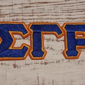 May include: Blue and orange embroidered patch with the letters "ΣΤΡ".
