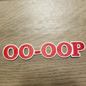 May include: Red embroidered patch with the text "OO-OOP" in white outline.