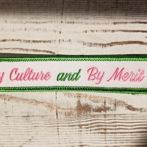 By Culture and By Merit iron-on embroidered 5" X 1" patch